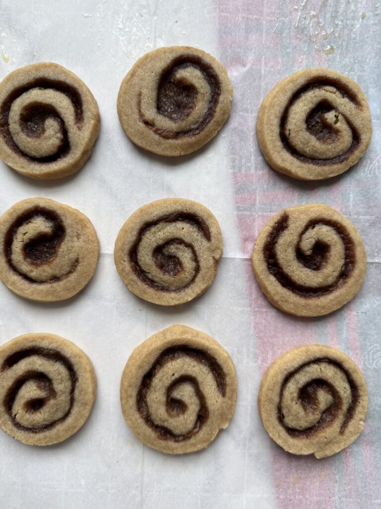 Pecan sticky bun cookies with a swirl on parchment paper