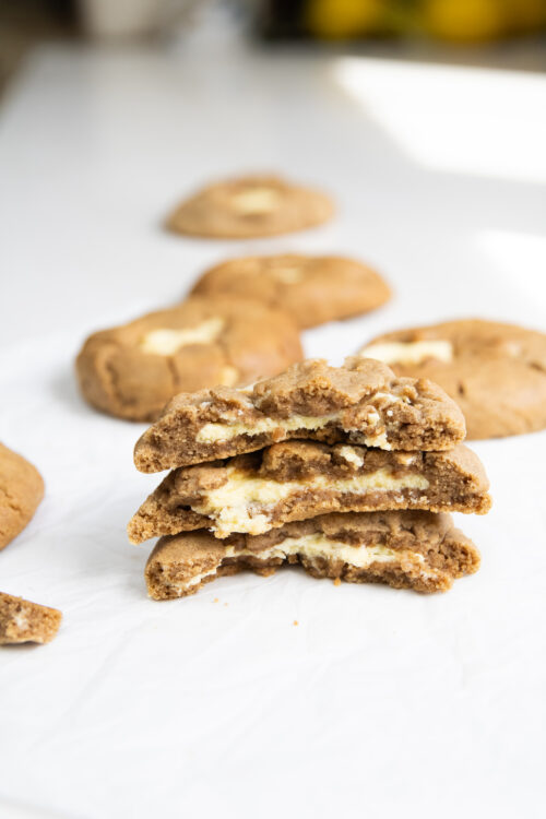 Carrot cake cookies stuffed with cream cheese stacked on plate