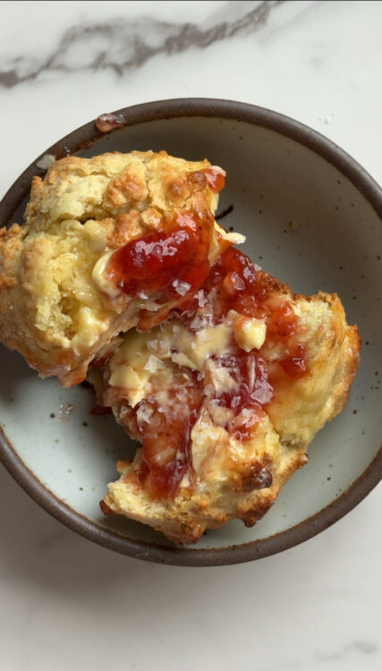 Warm Irish Soda bread scones topped with strawberry butter on plate with salt
